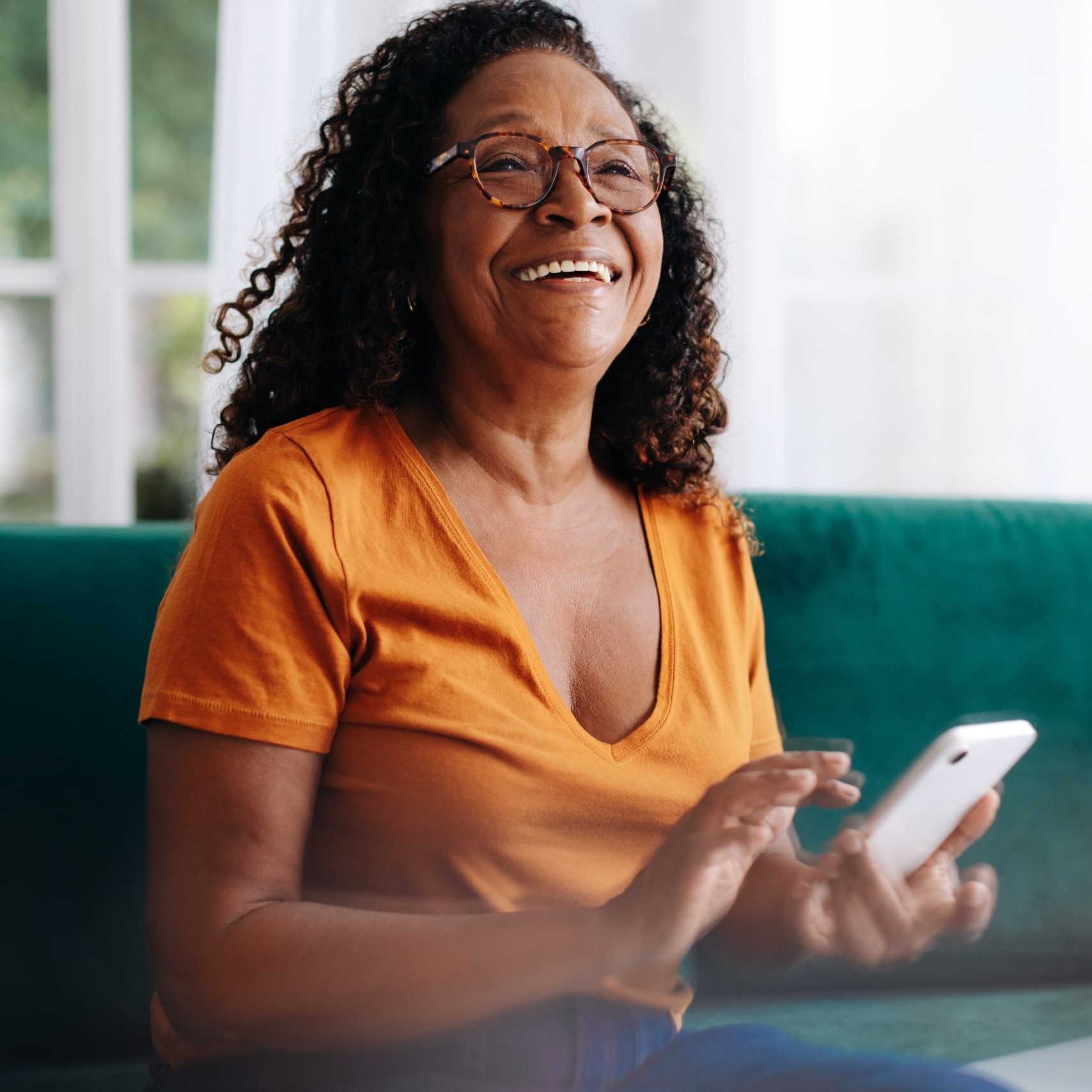 Retired woman using her smartphone to stay connected with her loved ones. Senior woman using mobile technology to make phone calls, send text messages, access social media, and browse the internet.