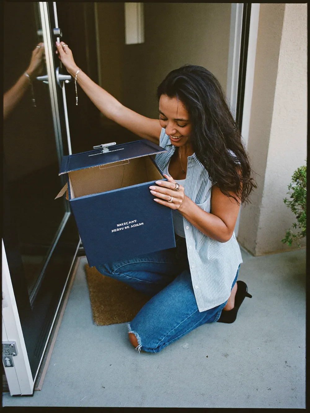 Woman opening a delivery box at her front door